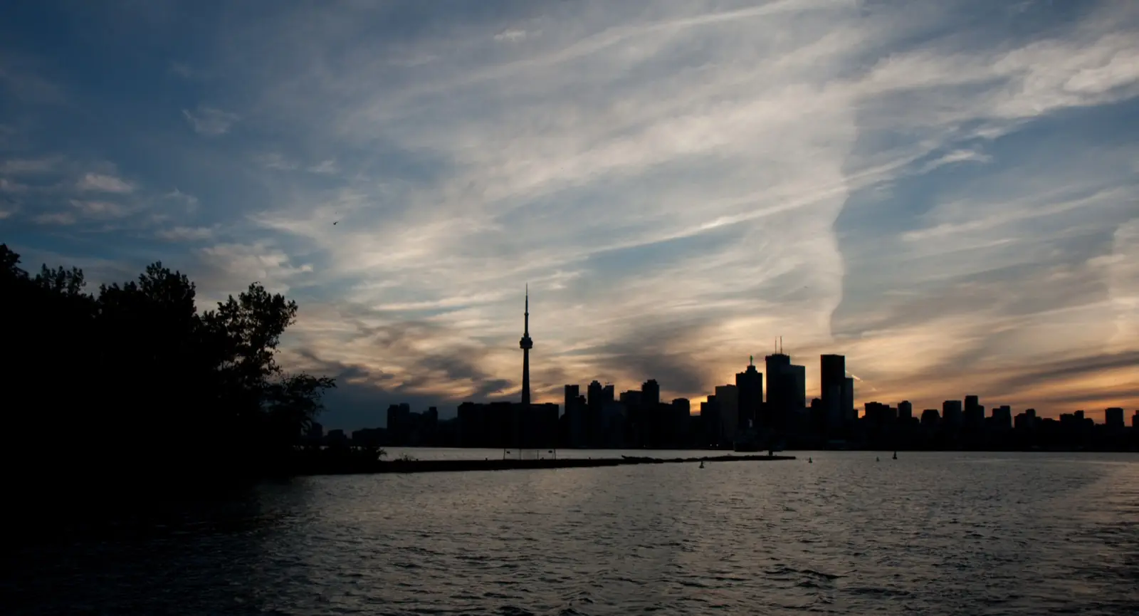 The Toronto skyline and the CN Tower at dusk, across the water